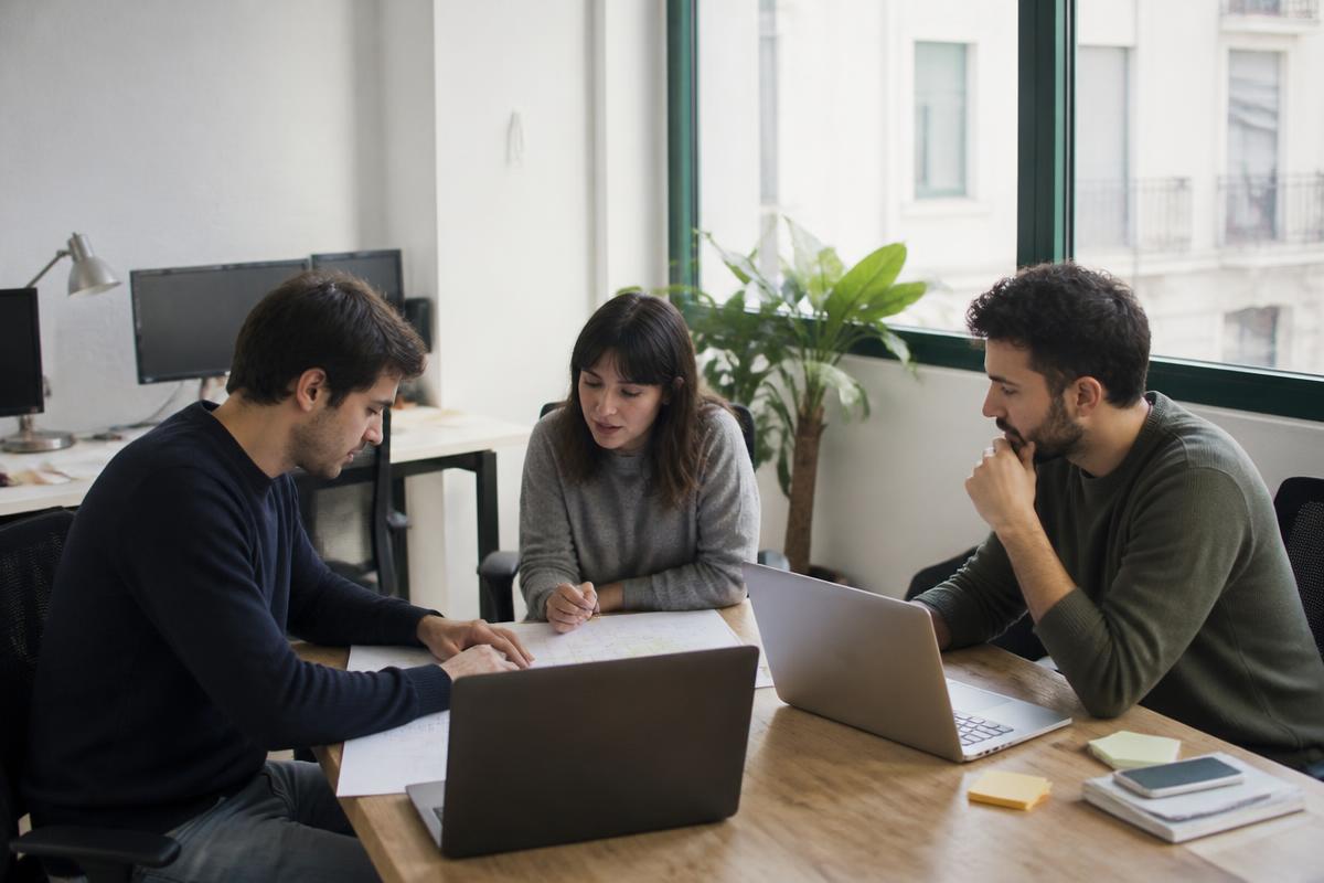 Equipo de una pequeña empresa de servicios digitales revisando documentación